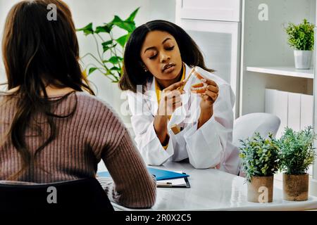 une femme dentiste explique au patient comment brosser les dents avec une bouche modèle Banque D'Images