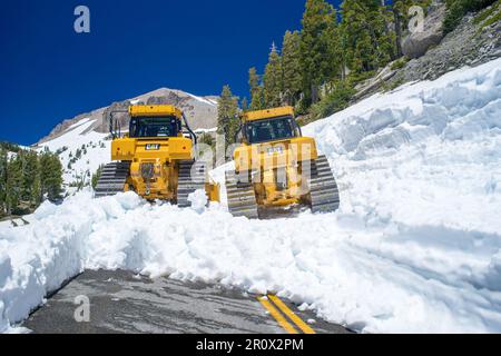 Deux bulldozers CAT jaunes. Déneigement important en juillet à Lassen, en Californie. Banque D'Images