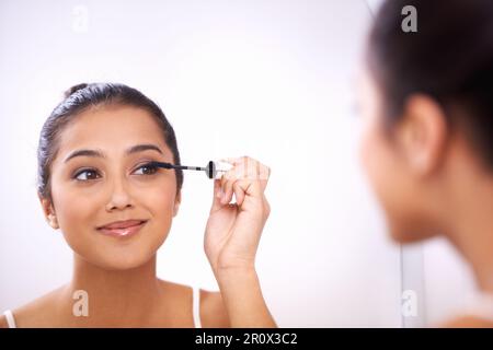 Faire éclater les yeux. Une magnifique jeune femme appliquant la mascara. Banque D'Images