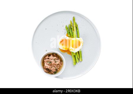 Mini asperges cuites avec œuf et thon. Isolé sur fond blanc Banque D'Images