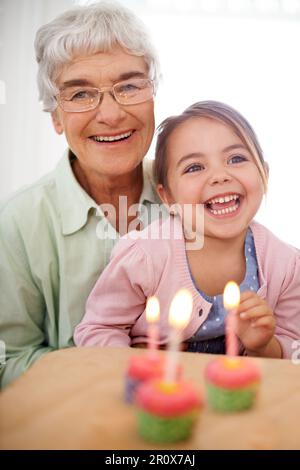 Trois ans aujourd'hui. Portrait d'une grand-mère heureuse célébrant un anniversaire avec sa petite-fille à la maison. Banque D'Images