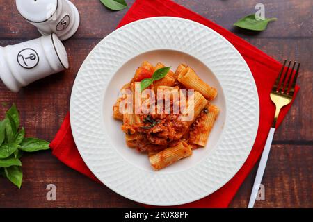 Le restaurant rigigatoni Pasta sert de la cuisine italienne traditionnelle et offre une vue imprenable sur une table en bois Banque D'Images
