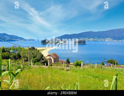 Plage de sable de Cesantes ville et l'île de San Simon (Galice, Espagne). Paysage d'été Ria de Vigo. Banque D'Images