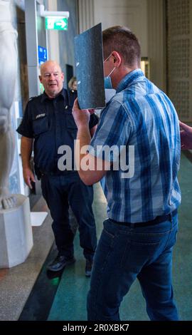 Schwerin, Allemagne. 10th mai 2023. Le défendeur de 32 ans est conduit dans la salle d'audience du tribunal régional au début du procès au sujet de l'incendie dans un refuge pour réfugiés pour Ukrainiens à Groß Strömkendorf. Selon la poursuite, le pompier présumé est responsable de toute une série d'incendies. Personne n'a été blessé dans l'incendie le 19 octobre 2022, et les 14 résidents et leurs soignants ont pu s'échapper à temps vers la sécurité. Credit: Jens Büttner/dpa/Alay Live News Banque D'Images