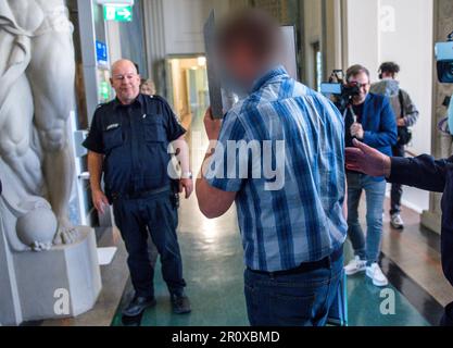 Schwerin, Allemagne. 10th mai 2023. Le défendeur de 32 ans est conduit dans la salle d'audience du tribunal régional au début du procès au sujet de l'incendie dans un refuge pour réfugiés pour Ukrainiens à Groß Strömkendorf. Selon la poursuite, le pompier présumé est responsable de toute une série d'incendies. Personne n'a été blessé dans l'incendie le 19 octobre 2022, et les 14 résidents et leurs soignants ont pu s'échapper à temps vers la sécurité. Credit: Jens Büttner/dpa - ATTENTION: Personne(s) ont été pixelated pour des raisons juridiques/dpa/Alay Live News Banque D'Images