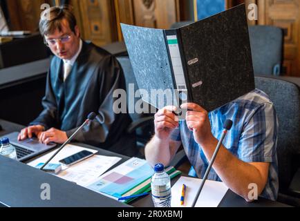 Schwerin, Allemagne. 10th mai 2023. Le défendeur, âgé de 32 ans, détient un dossier devant son visage à côté de son avocat Thomas Ruppel au début du procès au sujet de l'incendie dans un refuge pour réfugiés pour Ukrainiens à Groß Strömkendorf dans la salle d'audience du tribunal régional. Selon la poursuite, le pompier présumé est responsable de toute une série d'incendies. Personne n'a été blessé dans l'incendie le 19 octobre 2022, et les 14 résidents et leurs soignants ont pu s'échapper à temps vers la sécurité. Credit: Jens Büttner/dpa/Alay Live News Banque D'Images