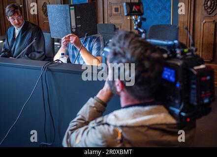 Schwerin, Allemagne. 10th mai 2023. Un caméraman filme le défendeur de 32 ans au début du procès au sujet de l'incendie dans un refuge de réfugiés pour Ukrainiens à Groß Strömkendorf dans la salle d'audience du tribunal régional. Selon la poursuite, le pompier présumé est responsable de toute une série d'incendies. Personne n'a été blessé dans l'incendie le 19 octobre 2022, et les 14 résidents et leurs soignants ont pu s'échapper à temps vers la sécurité. Credit: Jens Büttner/dpa/Alay Live News Banque D'Images