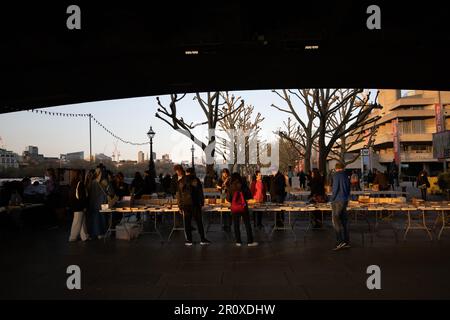 South Bank Book Market, les touristes s'arrêtent pour parcourir un marché de livres en plein air consacré uniquement aux livres situés sous le Waterloo Bridge, Londres, Royaume-Uni Banque D'Images