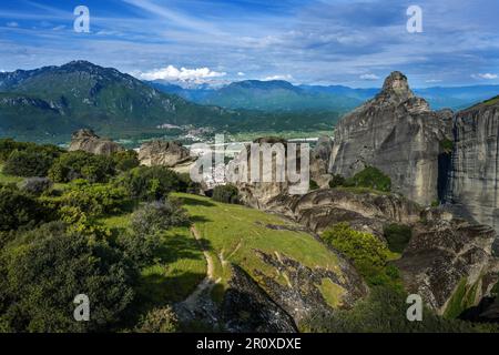 Vue depuis les rochers Meteora sur le village Kalambaka dans la vallée aux montagnes et sommets enneigés, paysage dans le centre de la Grèce, bleu nuageux Banque D'Images