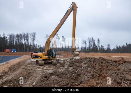 UST-Luga, oblast de Leningrad, Russie - 16 novembre 2021 : pelle Caterpillar avec longue fosse de creusement de flèche Banque D'Images