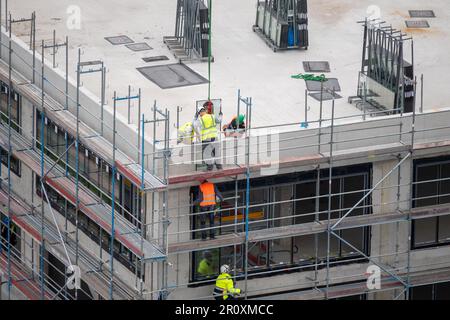 Vitrier installant des fenêtres sur un bâtiment commercial. Banque D'Images