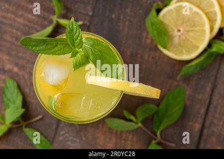 Limonade aux feuilles de menthe fraîche et tranche de citron en verre sur une table en bois Banque D'Images