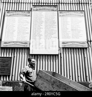 Rouleaux de hommes qui servent dans les forces armées sont affichés sur de grands panneaux au Fulton Fish Market à New York City, New York. juin 1943. Photographie par Gordon Parks/FSA Banque D'Images