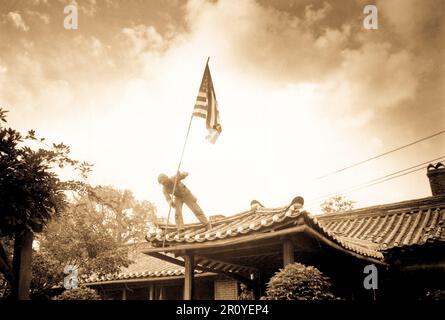 Les Pvt. 1re classe Luther Leguire soulève drapeau des États-Unis au consulat américain à Séoul, tout en luttant pour la ville a fait rage autour de l'enceinte. Le 27 septembre 1950. Photo par le Sgt. John Babyak, Jr. (Marine Corps) Banque D'Images