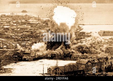 Entrepôts d'alimentation et d'installations portuaires à cet important port de la côte est se sentir le poids de la para-destructeur des bombes larguées de démolition de la 5ème Air Force B-26 Invader bombardiers légers, Wonsan, la Corée du Nord. Ca. 1951. Banque D'Images