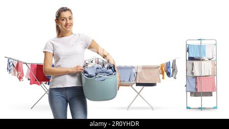 Jeune femme tenant un panier de chaise longue devant des lignes de vêtements isolées sur fond blanc Banque D'Images