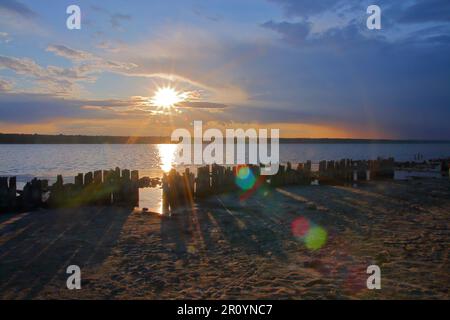 La photo a été prise en Ukraine, sur l'estuaire appelé Kuyalnik. La photo montre le coucher du soleil après une journée de débordement. Le rem se trouve également au premier plan Banque D'Images