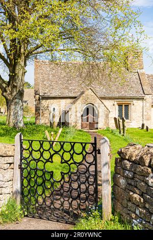 Église Saint-Laurent James dans le village de Cotswold, Clapton-on-the-Hill, Gloucestershire, Royaume-Uni. Porte en fer forgé en fer à cheval fabriquée par Raymond Phillips. Banque D'Images