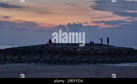 Pantai Jerman (plage allemande) à Kuta, Bali Indonésie vue au coucher du soleil montrant les gens appréciant la plage Banque D'Images