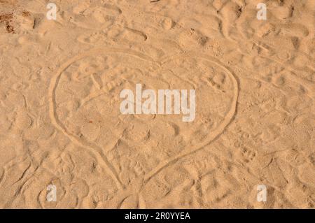 Coeur dessiné dans le sable par une journée ensoleillée Banque D'Images