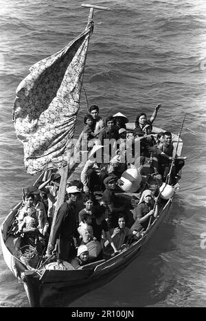 35 réfugiés vietnamiens attendent d'être pris à bord du navire de commandement amphibie USS Blue Ridge (LCC-19). Ils sont sauvés d'un bateau de pêche de 35 pieds à 350 miles au nord-est de Cam Ranh Bay, Vietnam, après avoir passé huit jours en mer. Banque D'Images