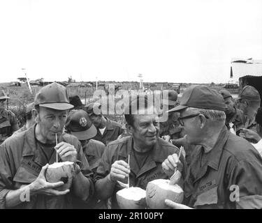 Pause pour des rafraîchissements lors de leur visite à Huu Thanh, un village récemment pacifié, trois États-Unis Les sénateurs du comité d'établissement des faits du président Nixon boivent des noix de coco locales. Le sénateur Thomas J. McIntyre, le sénateur Howard Cannon et le sénateur George Murphy. Vers 1970. Banque D'Images