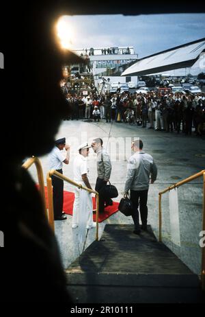 Vue depuis l'intérieur du C-141 comme deux ex-prisonniers sont accueillis à l'arrivée, après le vol de Hanoi, Vietnam du Nord, par (de gauche à droite) Le lieutenant général William G. Moore Jr., commandant de la 13e Air Force et l'amiral Noel Gaylor, commandant du Commandement du Pacifique. Banque D'Images