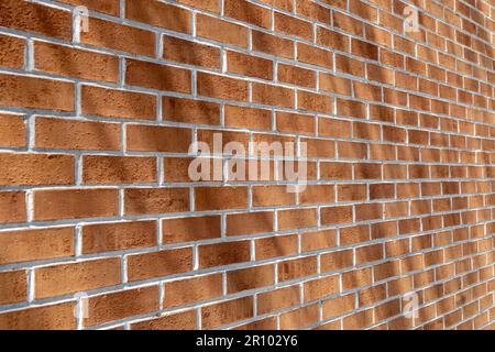 Gros plan de texture d'un mur moderne traditionnel en brique d'argile rouge en forme de lien courant (lien de brancard), avec des ombres diagonales Banque D'Images