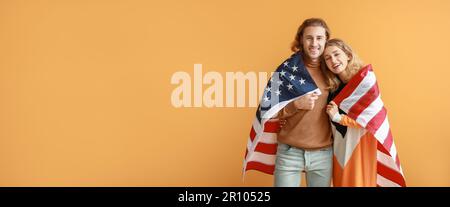 Jeune couple avec drapeau USA sur fond orange avec espace pour le texte Banque D'Images