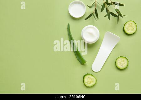 Composition avec pot de crème naturelle, ingrédients et spatule sur fond de couleur Banque D'Images