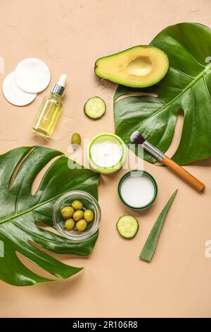 Composition avec des cosmétiques naturels, des ingrédients et des feuilles de palmier sur fond de couleur Banque D'Images