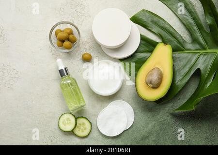 Composition avec cosmétiques naturels, ingrédients et feuille de palmier sur fond de grunge Banque D'Images