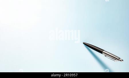 Un stylo à bille sur une feuille de papier bleu clair Banque D'Images