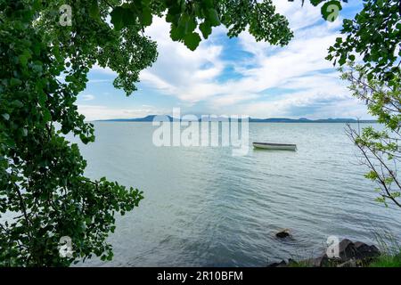 Bateau sur le lac Balaton avec le fond de Badacsonyhill à Balatonlelle avec cadre d'arbre Banque D'Images