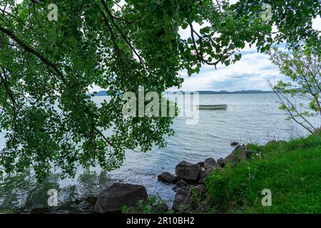 Bateau sur le lac Balaton avec le fond de Badacsonyhill à Balatonlelle avec cadre d'arbre Banque D'Images