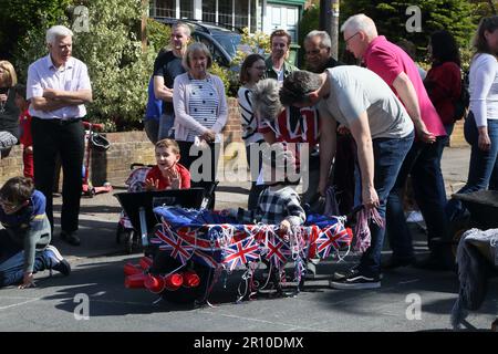 Familles participant à la course de brouettes à Street Party célébrant le Roi Charles III Coronation Surrey Angleterre Banque D'Images