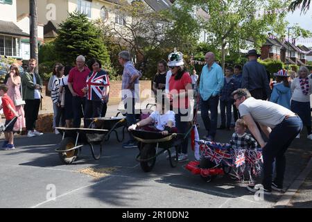 Familles participant à la course de brouettes à Street Party célébrant le Roi Charles III Coronation Surrey Angleterre Banque D'Images