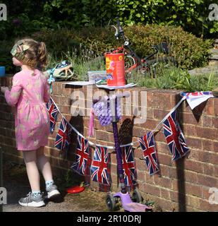 Jeune fille jouant avec Paper Crown trop grand couvrant ses yeux célébrant le King Charles III Coronation à Street Party Surrey Angleterre Banque D'Images