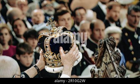 Le roi Charles III couronne couronnement moment, avec la couronne de Saint Edward tenu haut par l'archevêque Justin Welby à l'abbaye de Westminster avec le roi Charles III assis dans la chaise de couronnement Westminster London UK la couronne de St Edward est la pièce maîtresse des joyaux de la Couronne du Royaume-Uni. Nommé d'après Saint Edward le confesseur, des versions de celui-ci ont traditionnellement été utilisées pour couronner les monarques anglais et britannique à leur couronnement depuis le 13th siècle. Banque D'Images