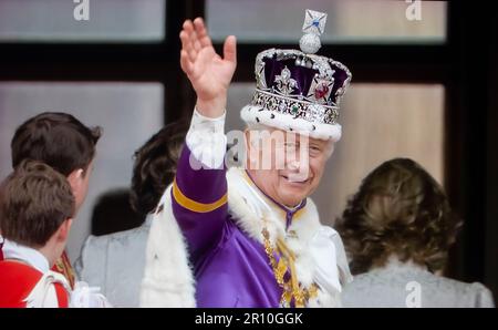 Le roi Charles III, qui agite depuis le balcon Buckingham Palace, porte la couronne d'État (la couronne d'État impériale) et ses robes de couronnement, signe un remerciement à la foule en contrebas, depuis le balcon de Buckingham Palace, après le couronnement de sa reine Camilla à Westminster Abbey Westminster London 6 mai 2023 Banque D'Images