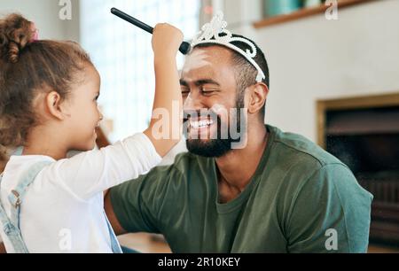 Faire ressembler papa à une vraie princesse. une petite fille mettant le maquillage sur son père tout en jouant ensemble à la maison. Banque D'Images