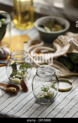 Vider les pots en verre et les ingrédients préparés pour être mis en conserve sur la table Banque D'Images