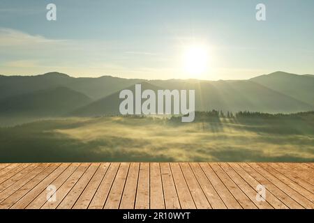 Surface en bois vide et belle vue sur le paysage de montagne brumeux Banque D'Images