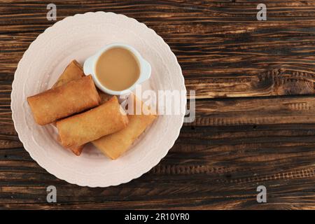 Lumpia ou Loenpia Goreng, rouleau de printemps frits profonds servi avec de la sauce aux arachides, habituellement rempli de poulet, de crevettes ou de légumes. Fritt indonésien typique Banque D'Images