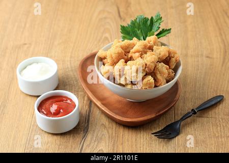 Poulet au popcorn sur un bol blanc avec sauce épicée et mayonnaise Banque D'Images