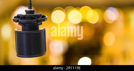 Microphone à condensateur professionnel pour enregistrer la voix sur fond bokeh doré. Podcast audio professionnel d'enregistrement de microphone. Équipement d'enregistrement Banque D'Images