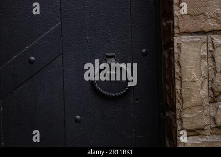 poignée ronde forgée sur un vieux gros plan de porte en fer noir Banque D'Images