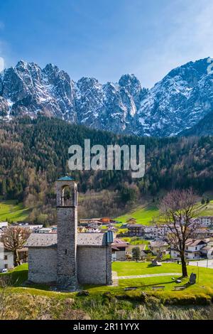 Vue aérienne de l'église appelée Cesulì avec la face nord de la montagne Presolana au printemps. Colere, Val di Scalve, Bergame district, Lombardie, Italie. Banque D'Images