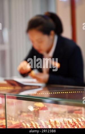 RENHUAI, CHINE - 11 MAI 2023 - Un client achète des bijoux en or dans un magasin d'or de la ville de Renhuai, dans la province de Guizhou, au sud-ouest de la Chine, au 11 mai 2023. Chine » Banque D'Images