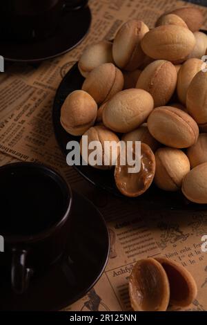 faites des photos de pâtisseries maison sur une assiette et du café sur un fond sombre Banque D'Images